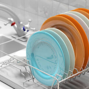 Dish drying rack with colorful clean plates on a white kitchen sink counter. 3d illustration